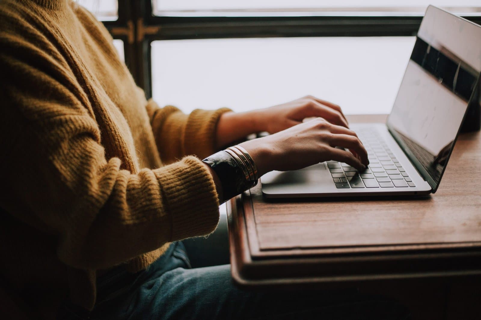 student typing on laptop