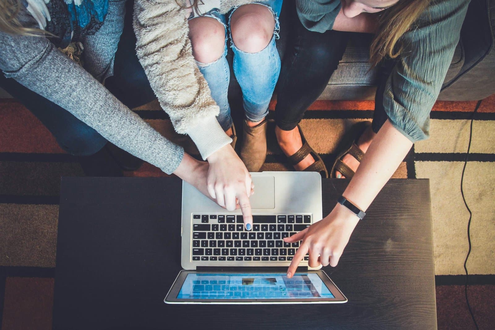 college students pointing at a laptop screen